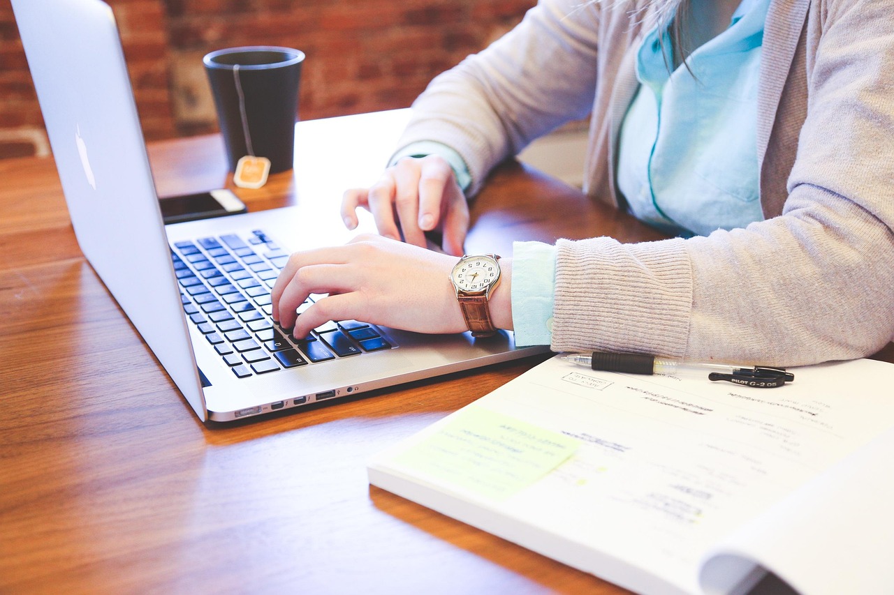 Person planning social media content on a phone and laptop
